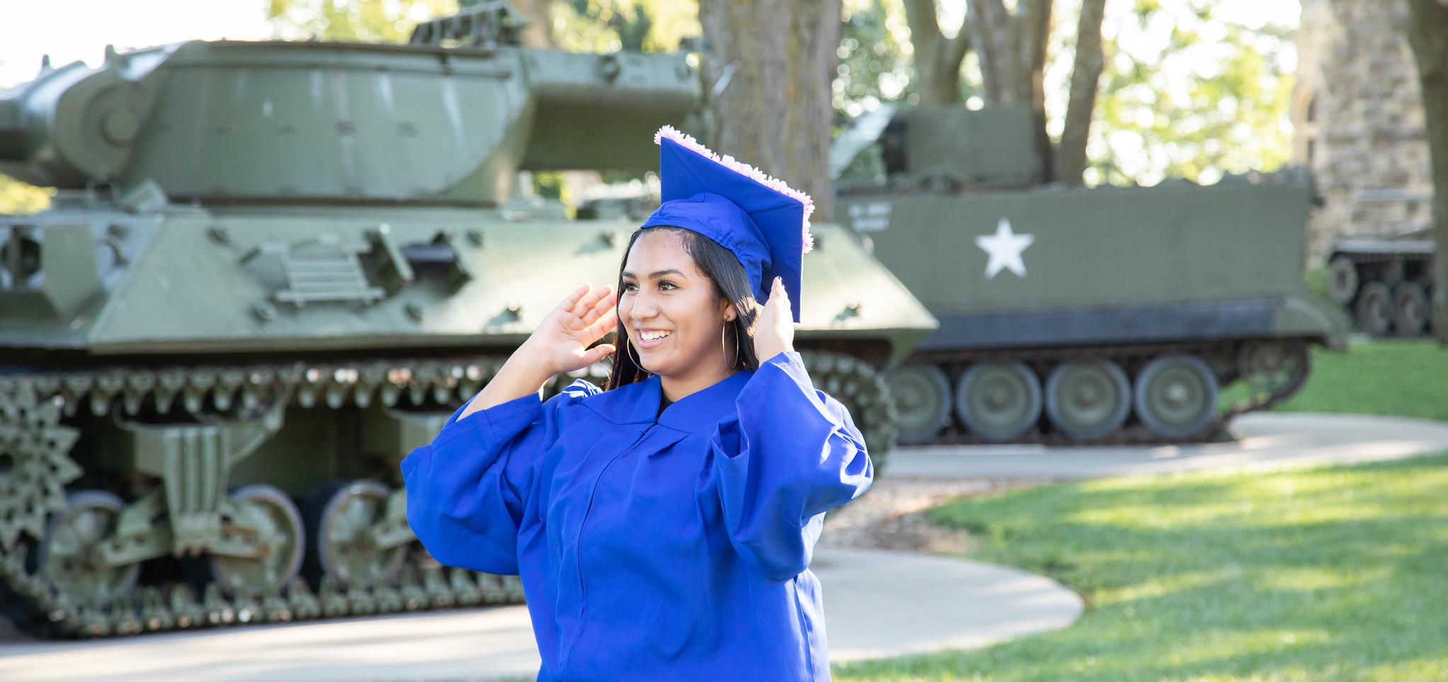 Graduate stands by tank
