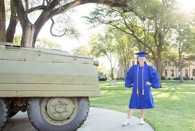 Graduate stands by tank