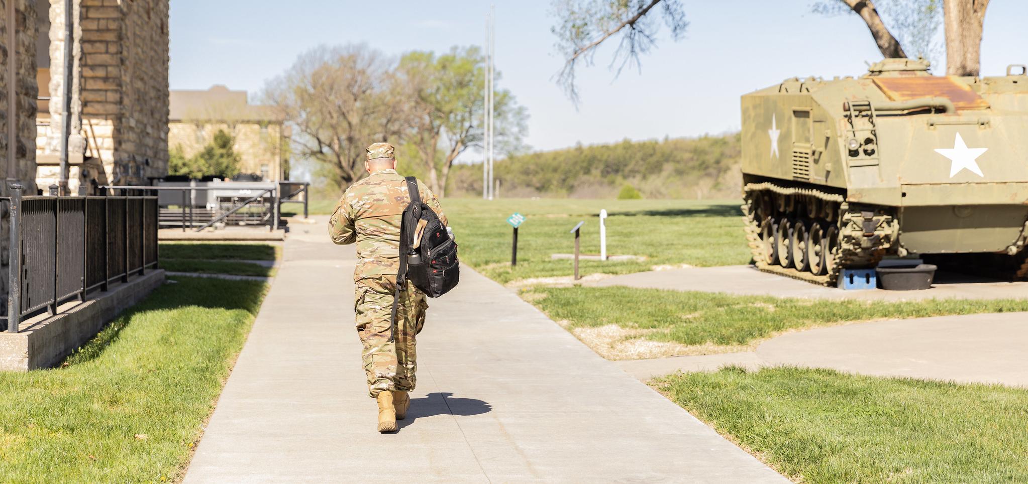 Soldier walks on campus with backpack