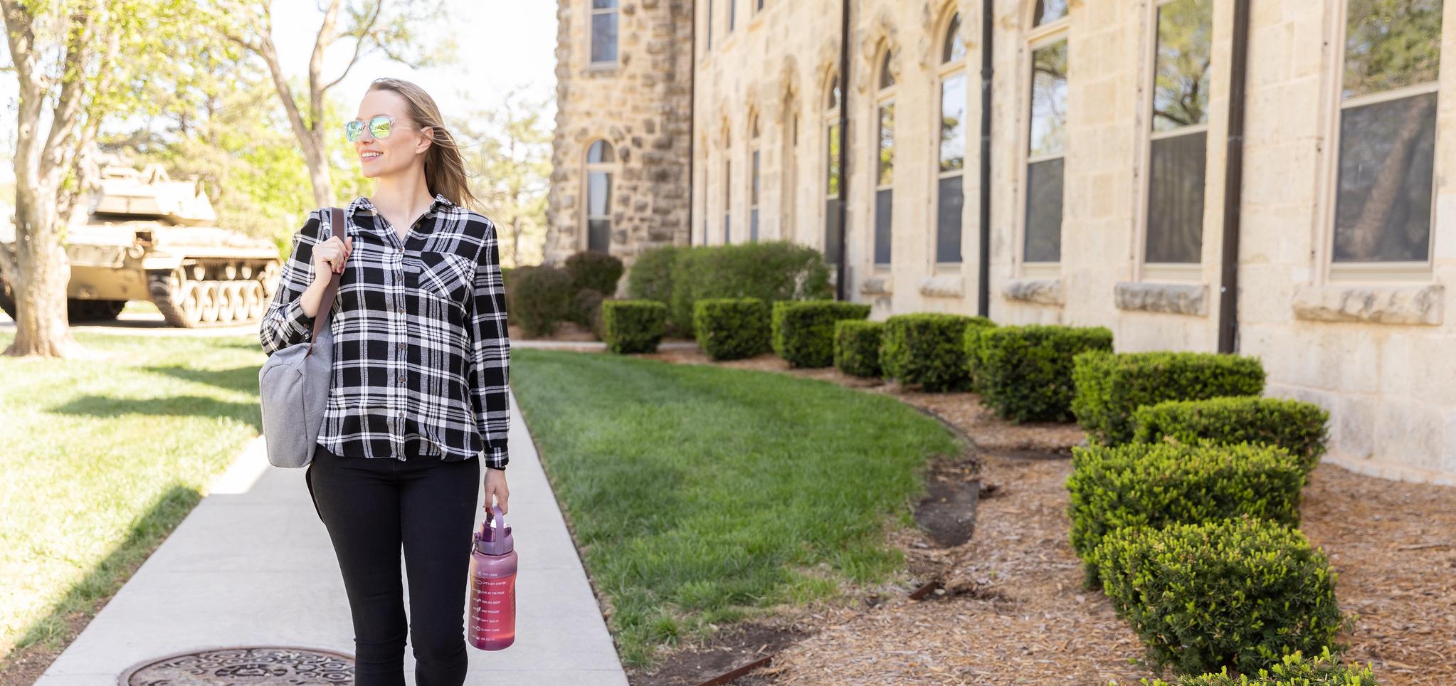 Barton Fort Riley student walks on a sidewalk on the Barton County Campus
