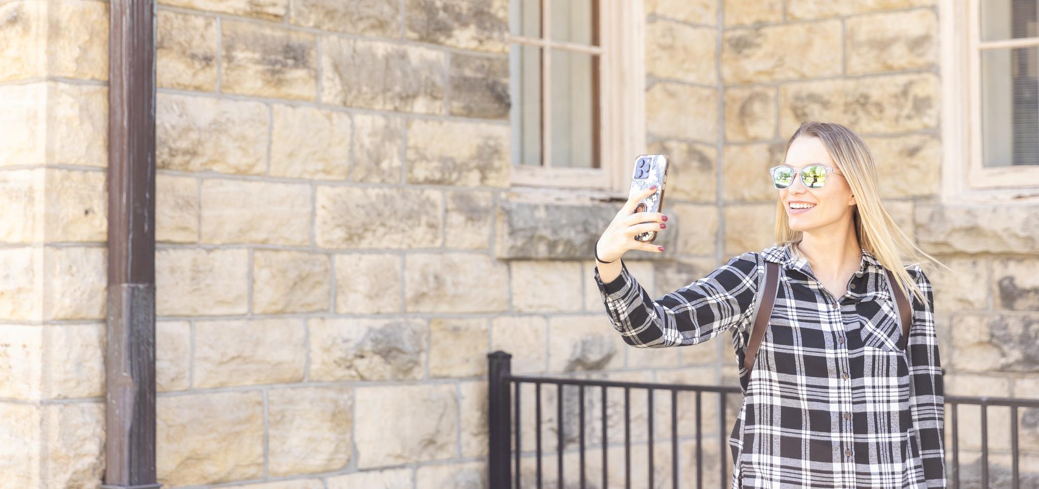 Student talks on phone on Fort Riley Campus