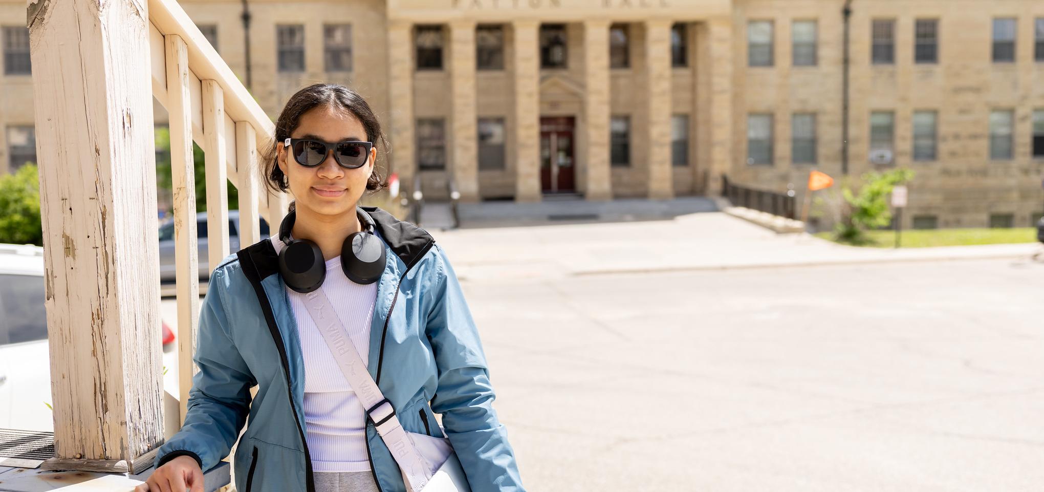 A student smiles outside hall on Fort Riley Campus